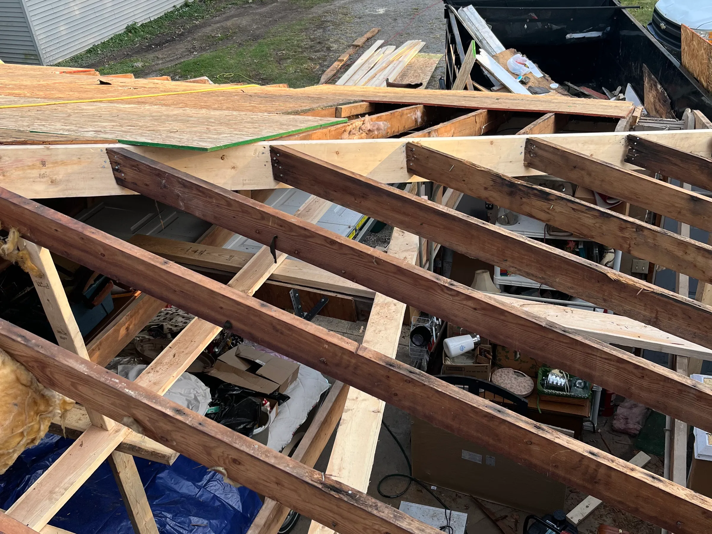 Wide view of completed roof work showing properly secured shingles, intact flashing around chimney, complete valley sealing, and uniform roof surface coverage with professional installation quality throughout.